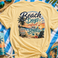Yellow t-shirt with 'Beach Days refuel my Soul' design on a blue and white striped towel with beach accessories.