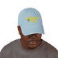 Man wearing a light blue cap with 'Caribbean Rays' logo on a white background
