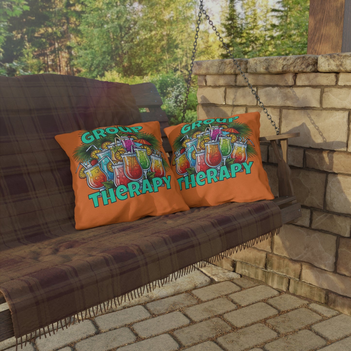 Two pillows with 'Group Therapy' design on a wooden swing outdoors.