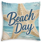 A square decorative throw pillow featuring a beach-themed print with a large starfish, blue ocean waves, seashells, palm leaves, and the words “Beach Day” in navy script over a light blue background.