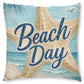 Square beach-themed throw pillow featuring a large starfish, seashells, ocean waves, palm leaves, and the words 'Beach Day' in navy script over a light blue and beige print, shown on a white background.