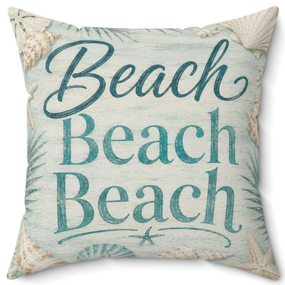 A square decorative throw pillow with a beach-themed print featuring the text 'Beach Beach Beach' in teal script and block letters, surrounded by seashell and palm leaf motifs on a light blue and beige background.