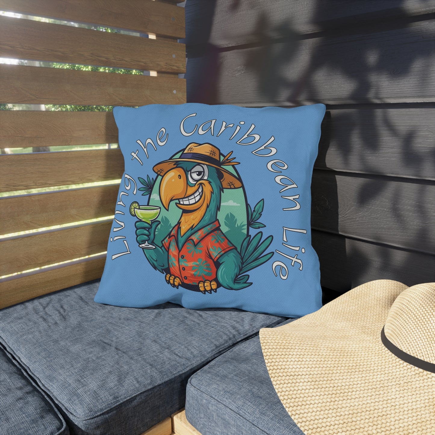 Pillow with a tropical parrot design and text 'Living the Caribbean Life' on a wooden bench.
