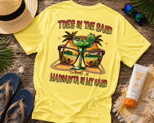 Yellow t-shirt with a beach-themed design on a wooden surface with accessories.