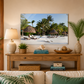 Living room with a wooden console table, lamp, books, and decorative items against a beach scene wall art.