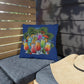 Decorative pillow with tropical drink design on a gray cushioned chair outdoors.