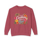 A dusty rose crewneck sweatshirt featuring a colorful graphic on the chest with tropical flowers and the text 'I'm in a Caribbean State of Mind'.