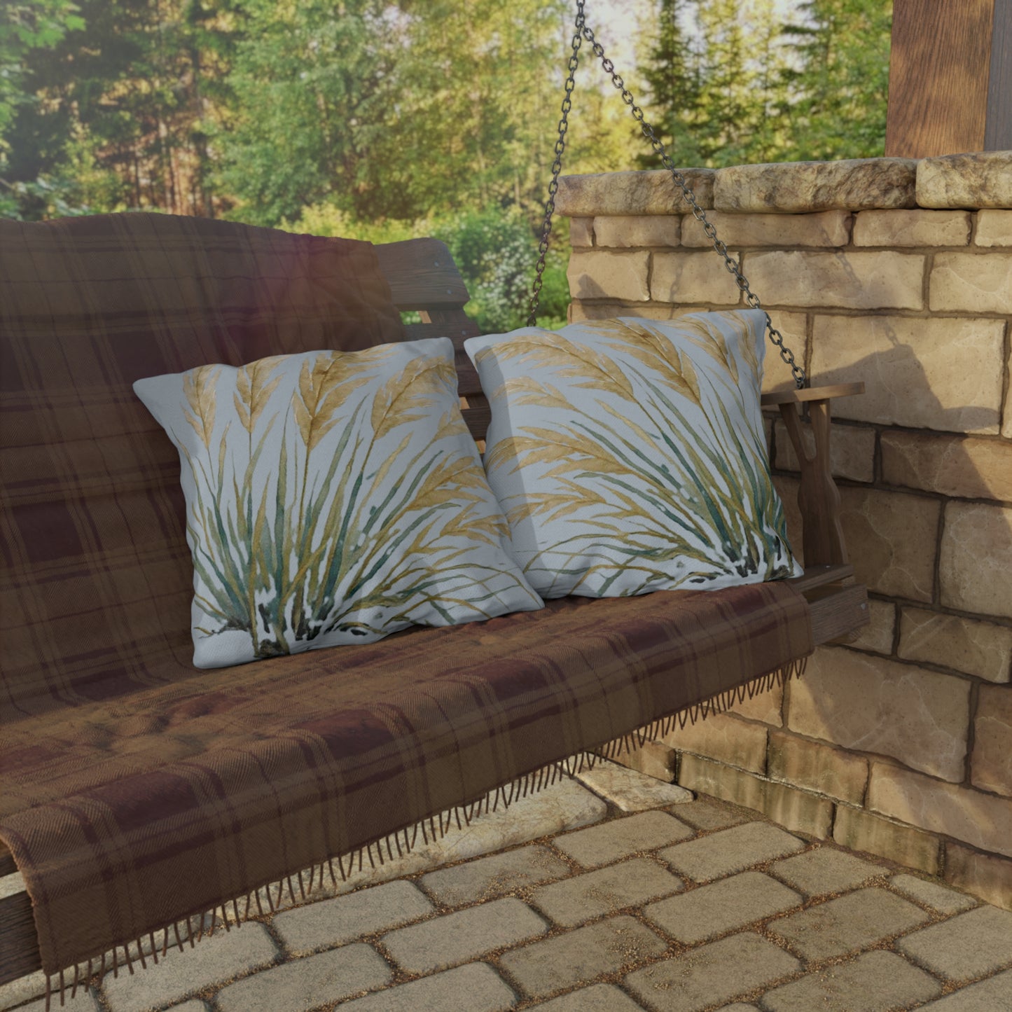 Wooden swing with plaid fabric and patterned cushions on a stone patio