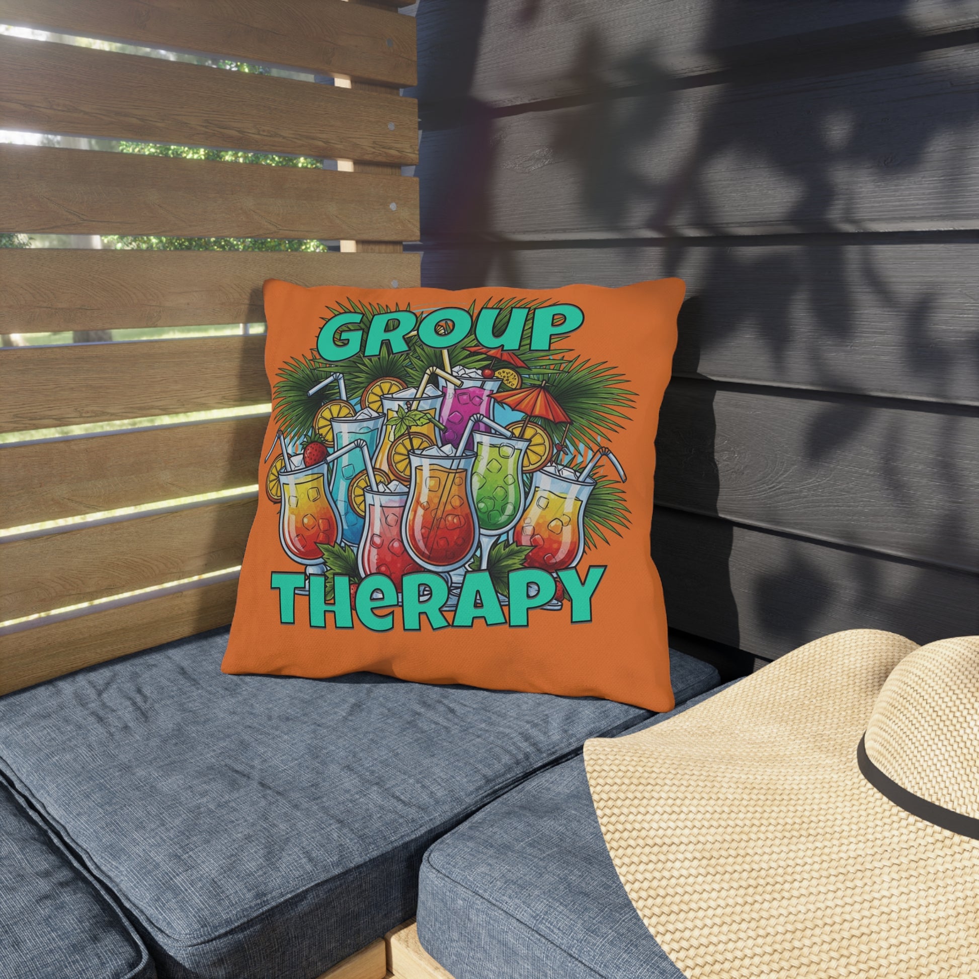 Orange pillow with 'Group Therapy' text and cocktail graphics on a patio setting.