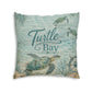 Square turquoise cushion with sea turtles and “Turtle Bay” lettering, leafy seaweed design