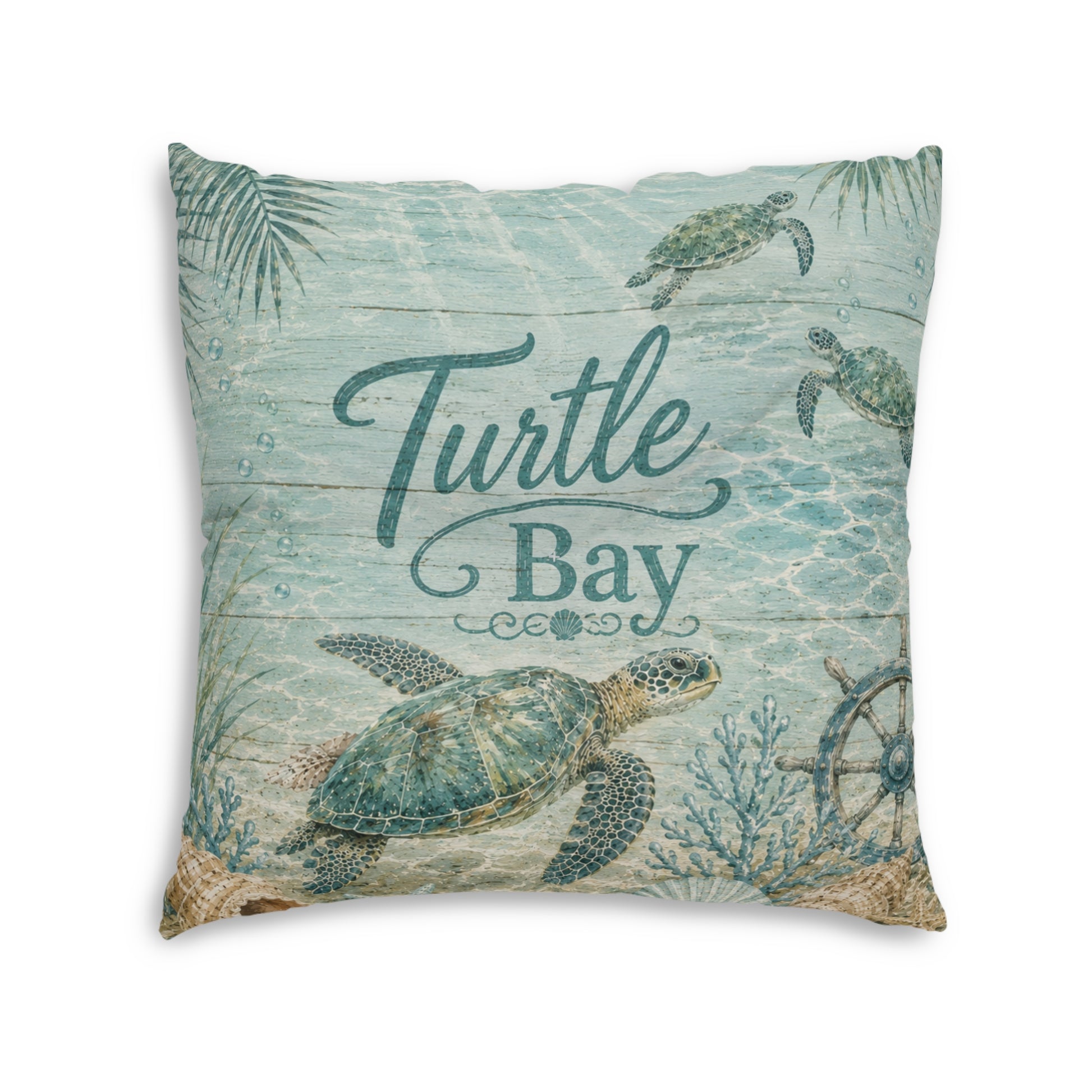 Square turquoise cushion with sea turtles and “Turtle Bay” lettering, leafy seaweed design