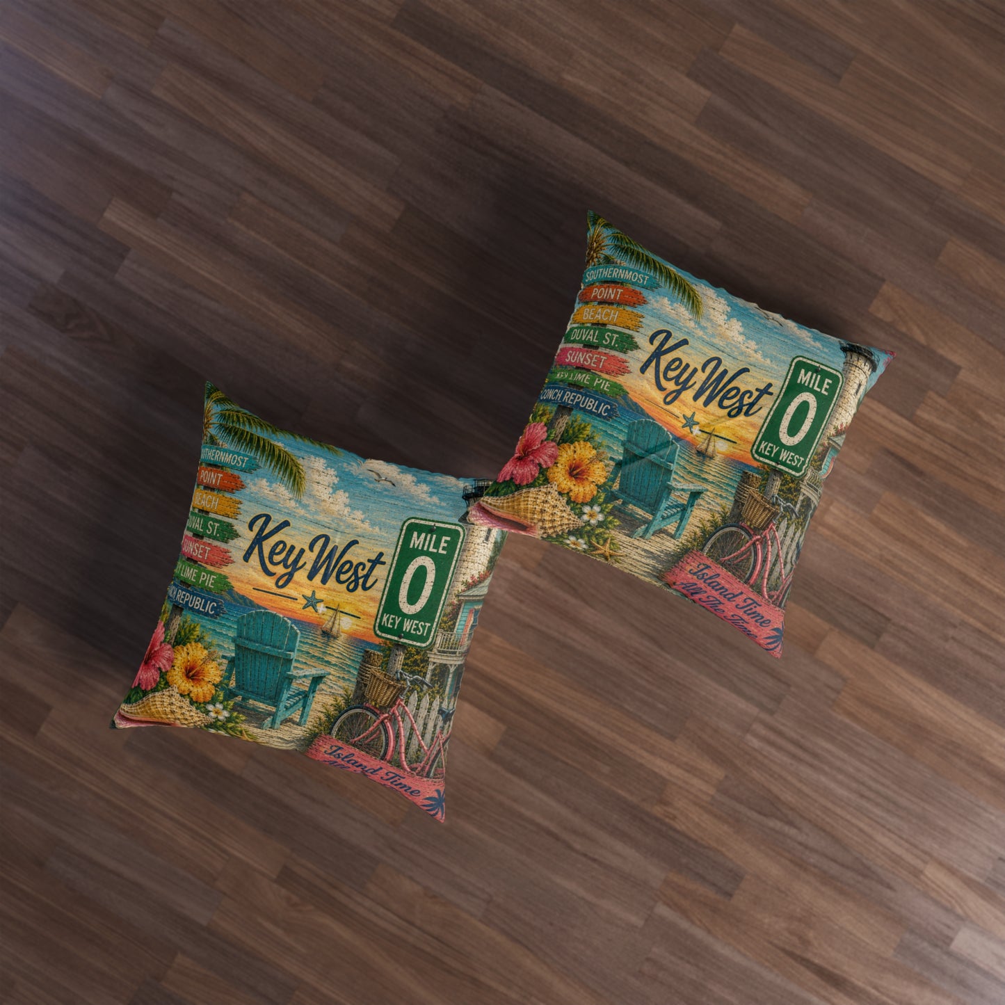 Two square decorative throw pillows with a colorful retro Key West beach scene print, placed on a dark brown wood floor.