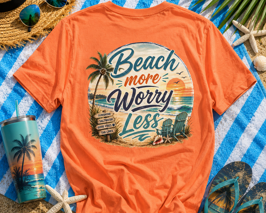Orange t-shirt with beach-themed design on a blue and white striped towel with beach accessories.