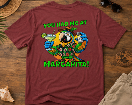 Maroon t-shirt with a parrot graphic and text on a wooden surface with accessories.