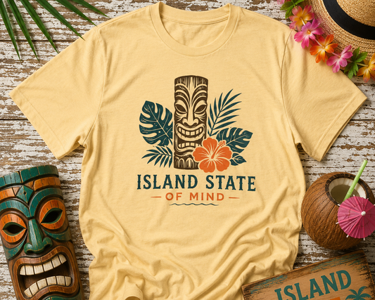 Beige t-shirt with 'Island State of Mind' design on a wooden surface with tropical decor.