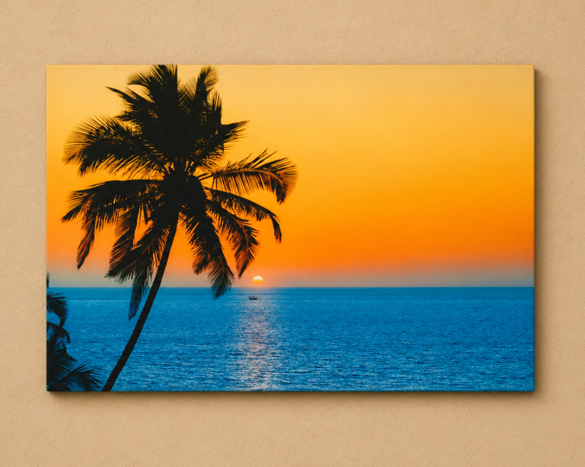 A rectangular wall art print showing a tropical sunset scene with a dark palm tree silhouette, blue ocean water, and a glowing orange sky, mounted against a beige wall.