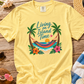 Yellow t-shirt with tropical design on a wooden surface with beach accessories.
