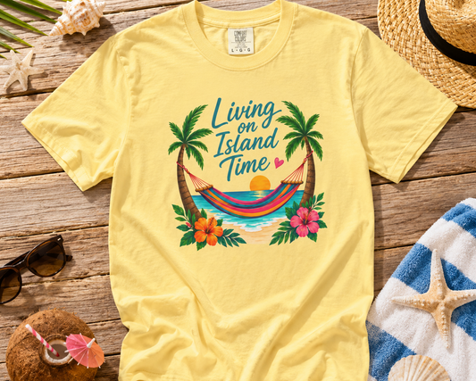 Yellow t-shirt with tropical design on a wooden surface with beach accessories.