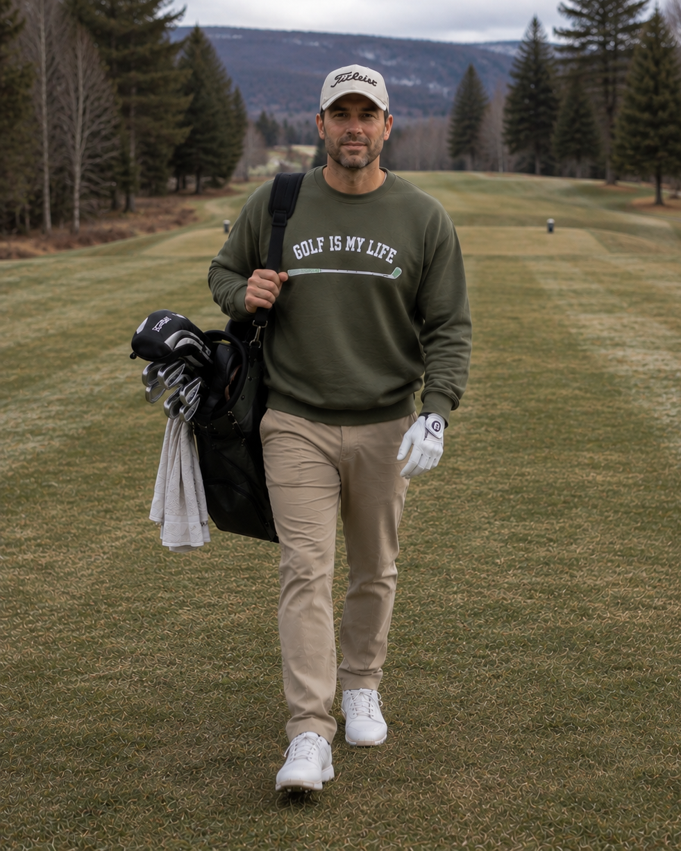 a man walking in a fairway wearing  a Green sweatshirt with 'Golf Is My Life' printed on it against a white background