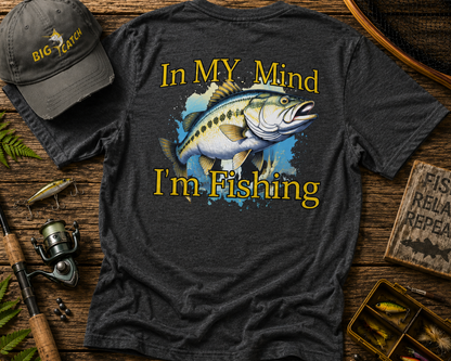 Dark gray t-shirt with fishing graphic and text on a wooden surface with fishing gear.