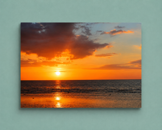 Sunset over water with orange and purple hues on a light blue background