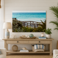 Living room with a large TV displaying a beach scene, wooden console table with decor items, and a plant.