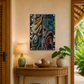 Decorative interior with a wooden console table, lamp, and artwork on the wall.