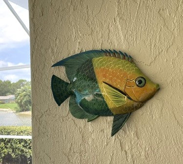 Tropical resin fish wall decor mounted on wall, blue-green and orange scaled body, fins