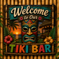 Decorative sign for a tiki bar with a colorful mask and sunset design.